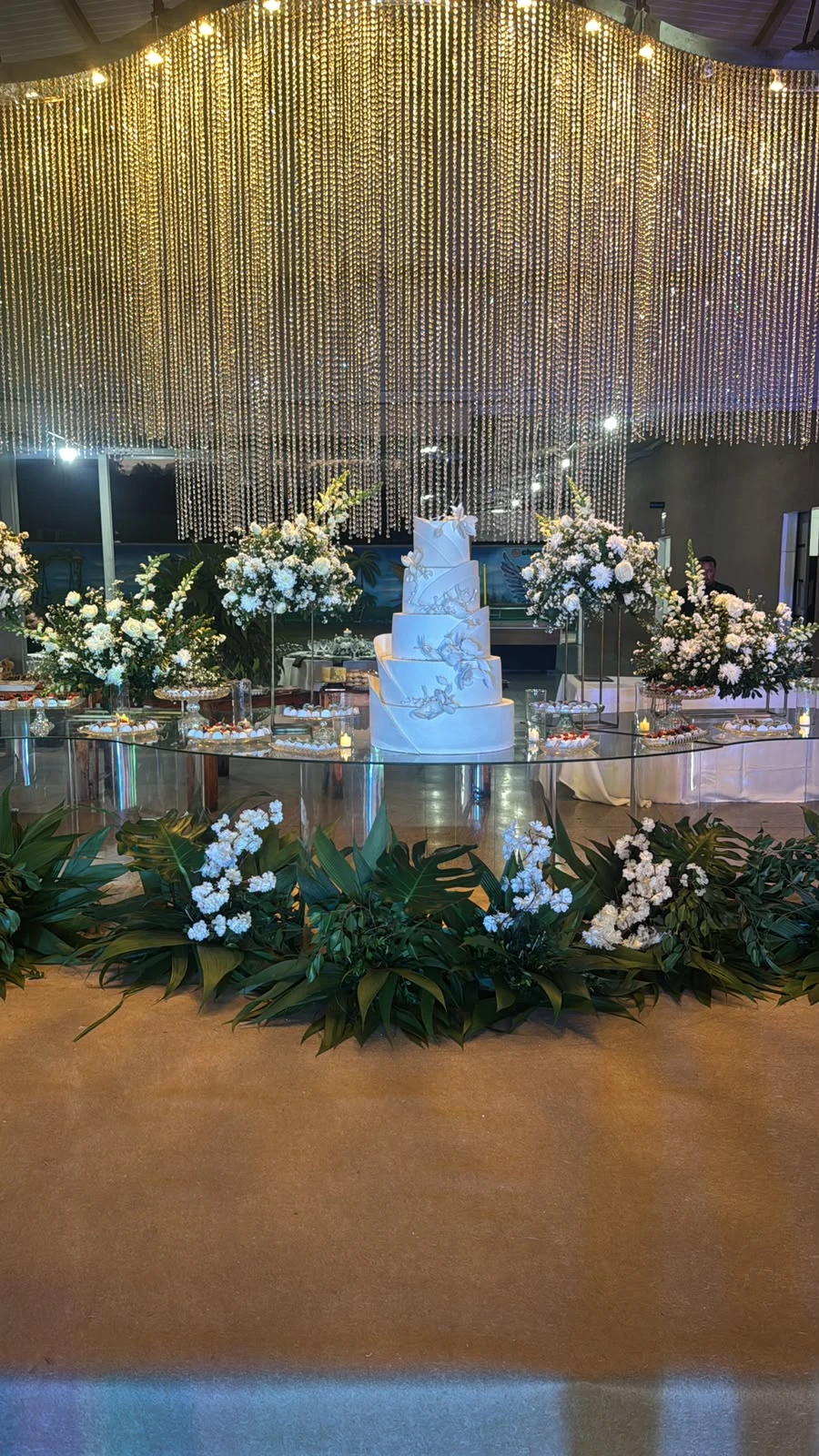 Mesa de bolo e flores no salão